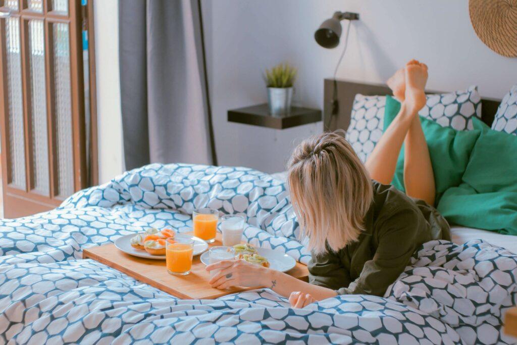 mujer desayunando encima de la cama